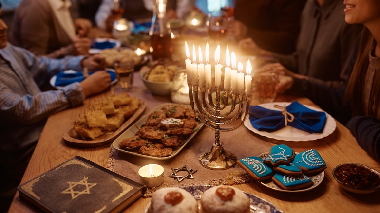 menorah lit on the dinner table 