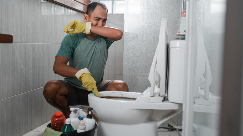 man cleaning in smelly bathroom