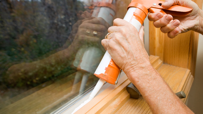 person using caulk gun