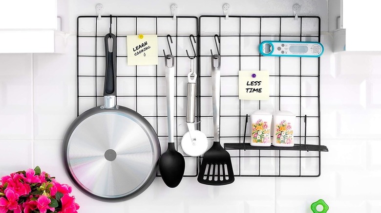 A grid wall panel supporting a variety of kitchen items