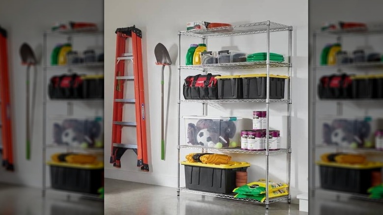 The HDX shelving unit with various cans of paint, bins, hoses, and potting mixes on top