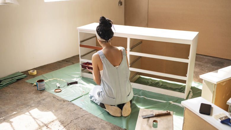 Woman works on flipping a white basic IKEA dresser into a vintage glam showstopper.