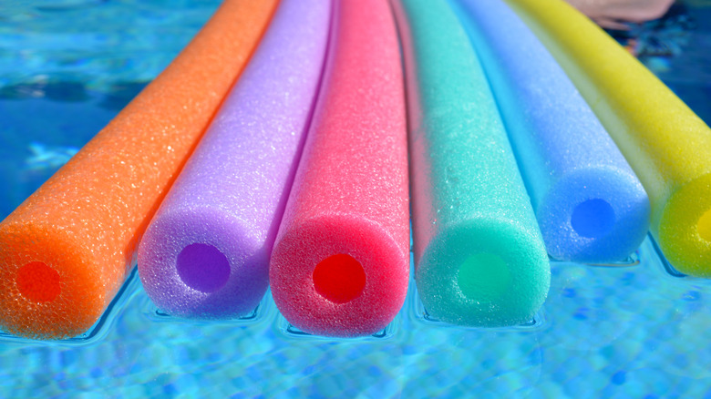 Colorful pool noodles floating in a pool