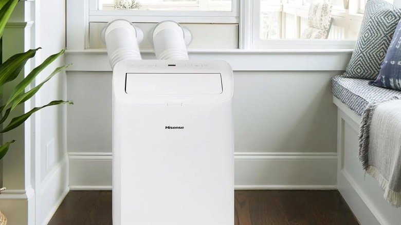 A hisense portable AC unit installed in a home next to a window.
