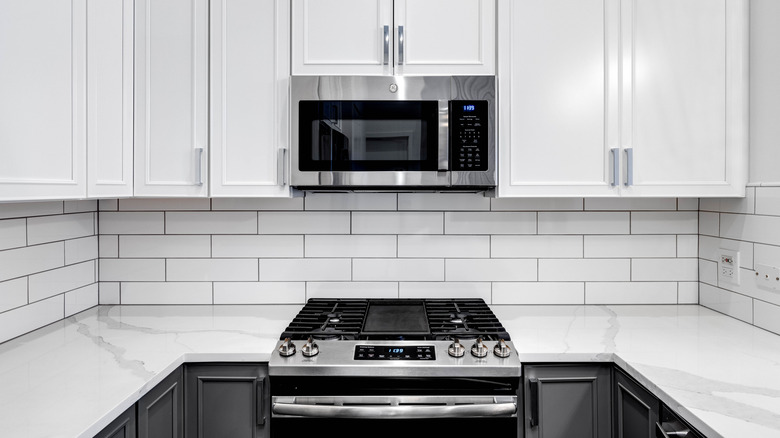 A GE range and microwave in a white kitchen