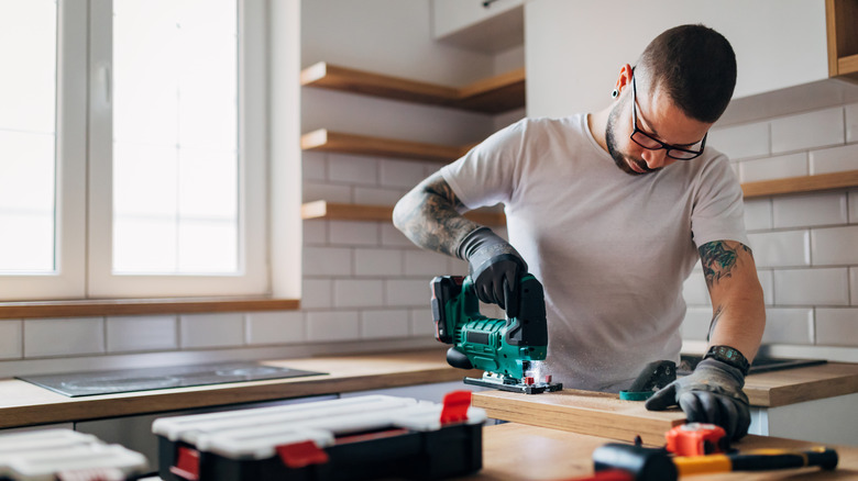 Tattooed man using power tools