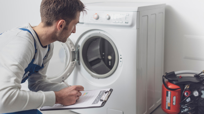 man looking at washing machine