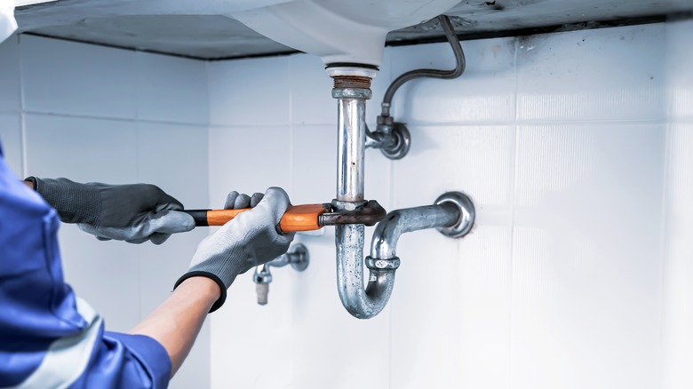 plumber fixes sink