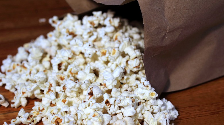 popcorn spilling from a brown paper bag