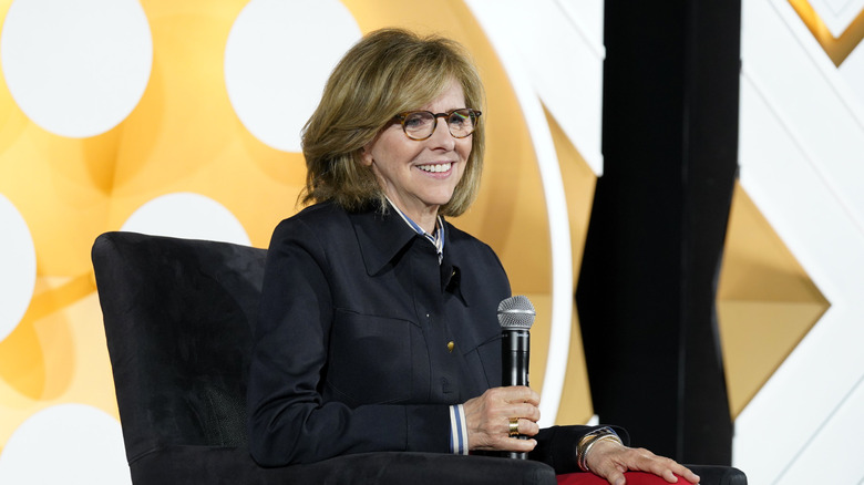 Nancy Meyers smiling with a microphone in hand