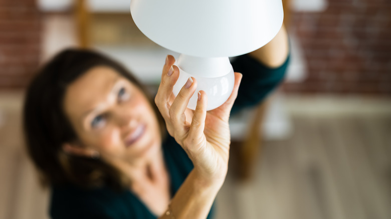 woman screwing in light bulb