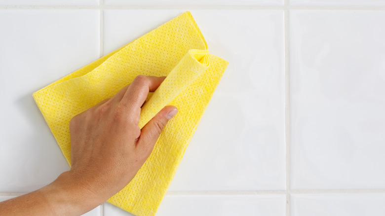Person cleaning tile surfaces