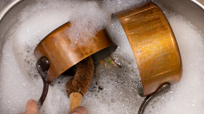 Copper pots in soapy water