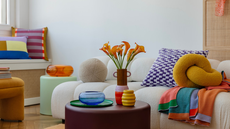 Modern living room with color pillows, vases, and furniture