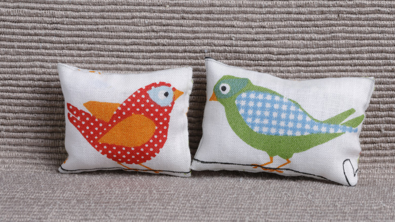 A pair of needlepoint bird pillows