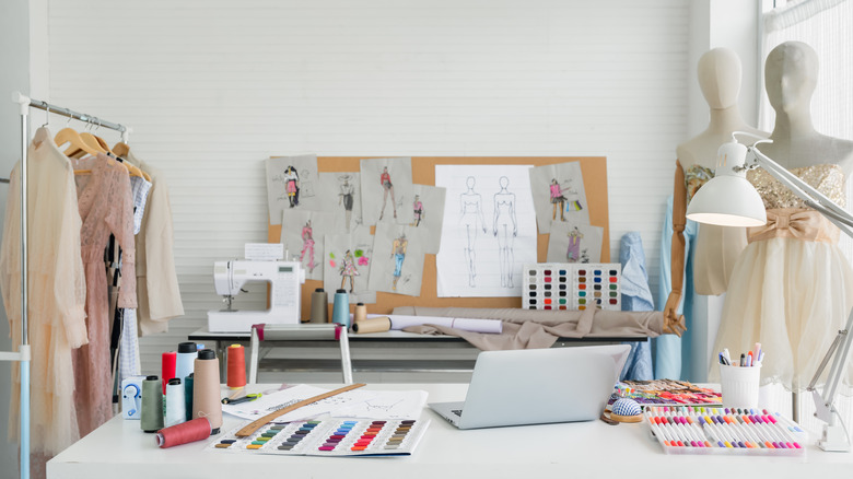 A room filled with clothes, designs, mannequins, and sewing tools