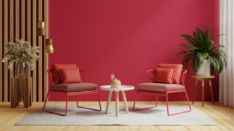 A red wall with red chairs and light wood accents in an open space