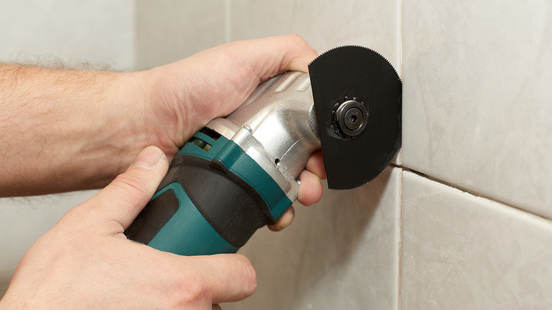 hands removing grout with machine