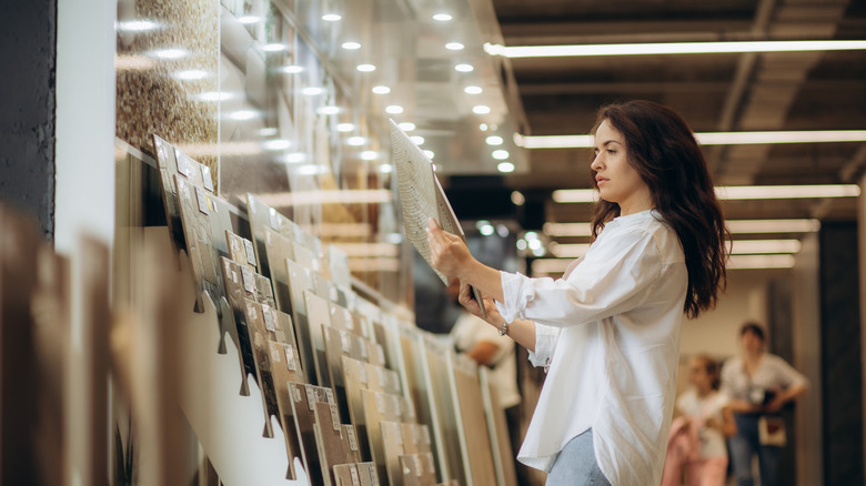 woman looking at flooring samples in a store