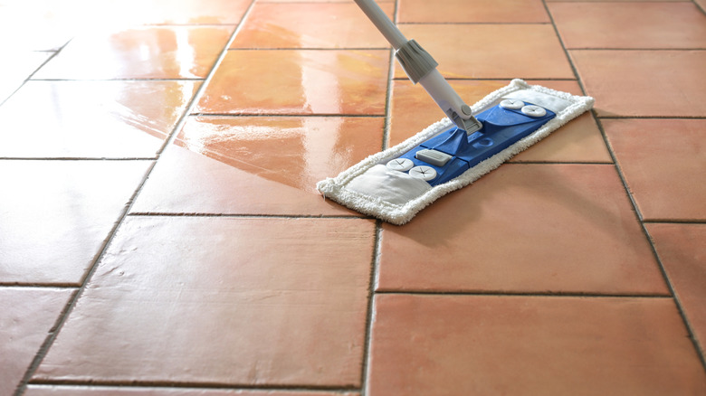 someone mopping terracotta tiles