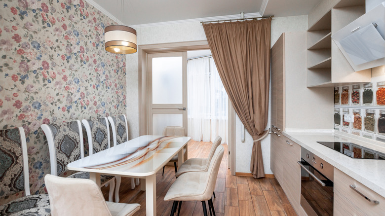 Small modern light-colored kitchen with floral wallpaper on one wall