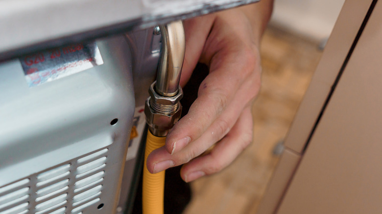 person installing yellow gas connector