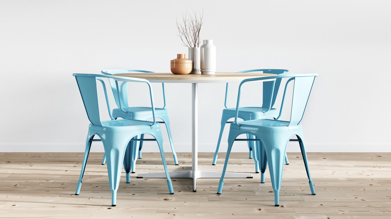 An office table surrounded by painted metal chairs
