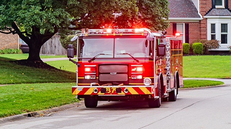 Firetruck with its lights on in a neighborhood