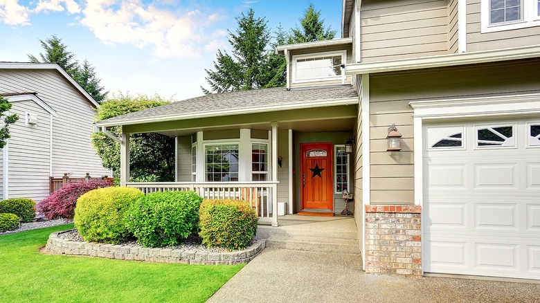 Home exterior with lawn, porch, and garage.