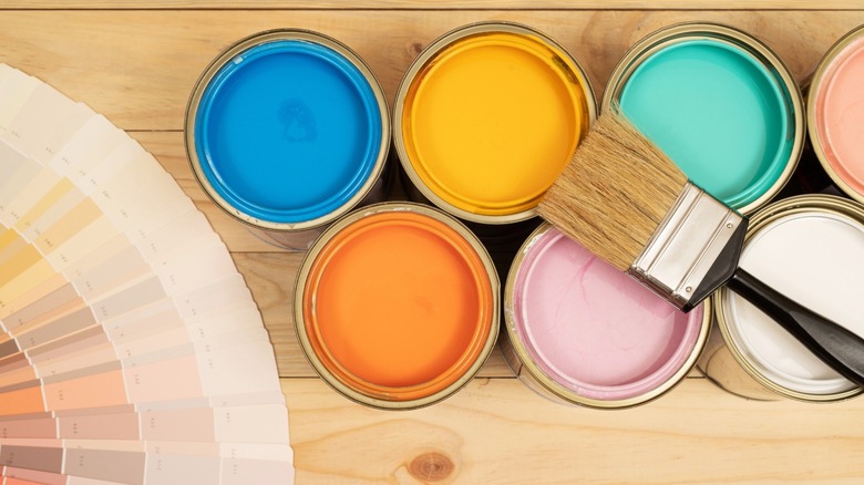 Color palettes, paint cans, brush