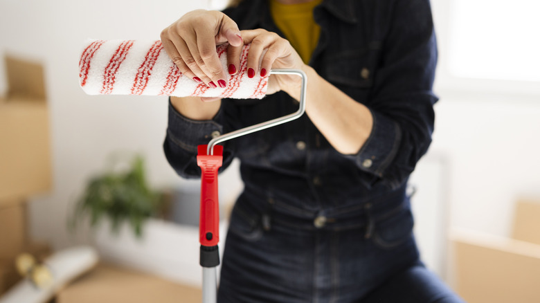 Person holding paint roller 