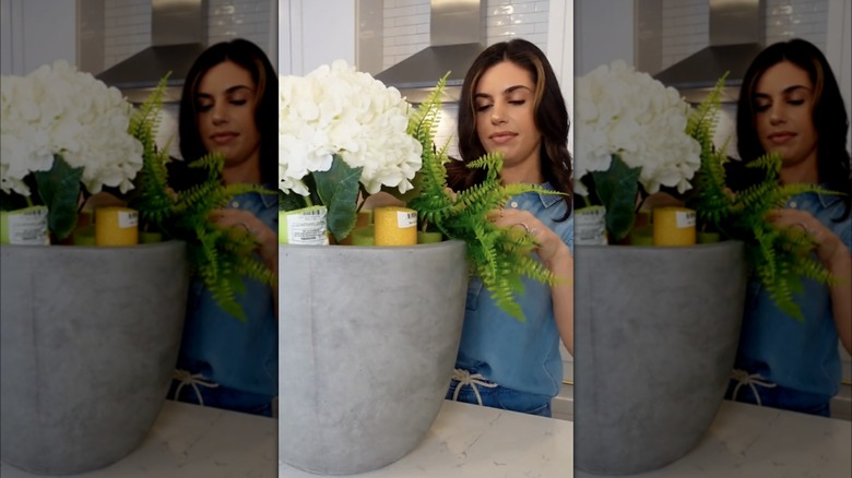 Woman placing flowers in pool noodles