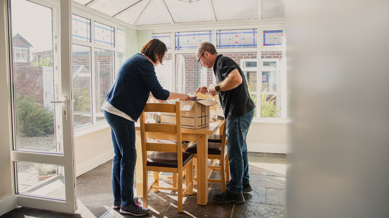 couple standing in dining room with solarium