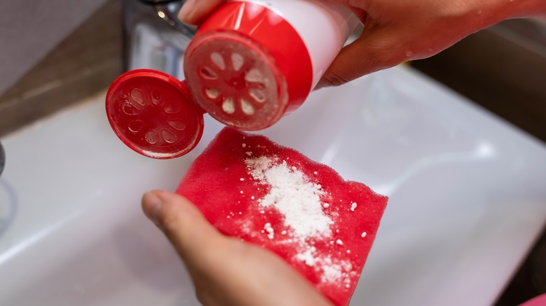 Pouring powdered cleaner on sponge