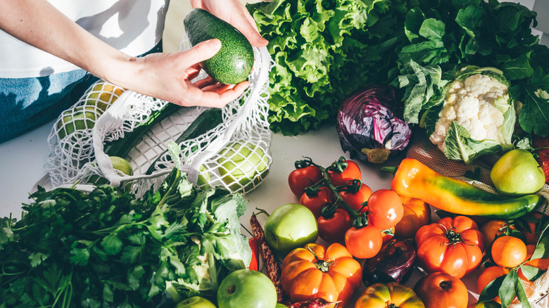 Woman's hand taking produce out of a mesh bag