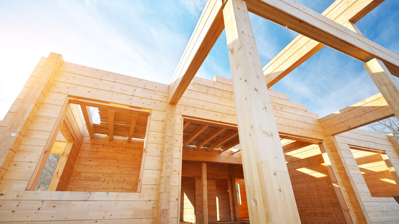 An angled shot of a timber-framed home under construction