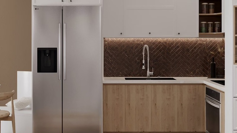 the LG side-by-side fridge in a modern kitchen with a herringbone backsplash and wood cabinetry
