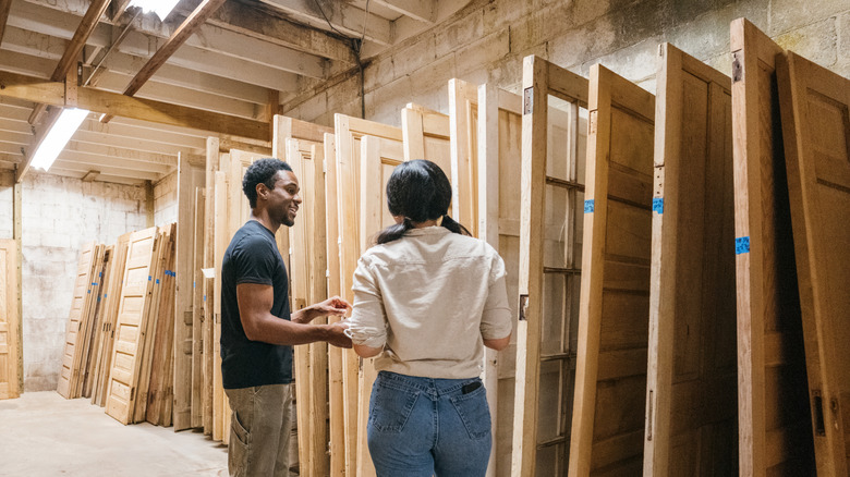 a couple browsing through various types of doors