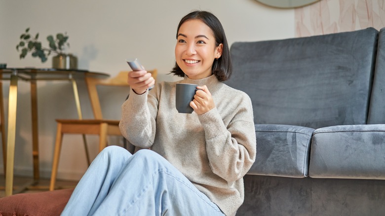 Woman watching TV in living room