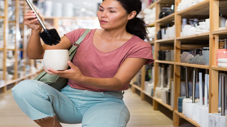 Woman looking at toilet bowl brush in store