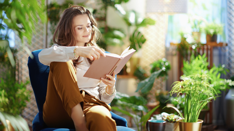 woman reads near plants
