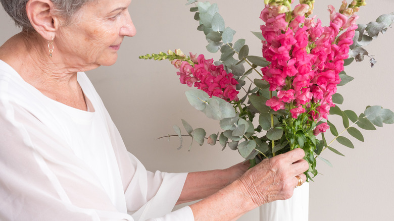 person arranging flowers in vase