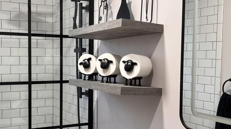 Sheep-style toilet roll holders on a shelf in the bathroom