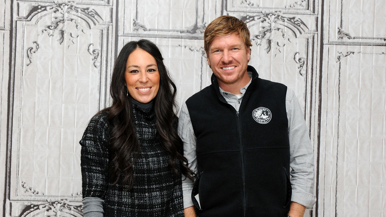 Chip and Joanna Gaines together in front of detailed home backdrop