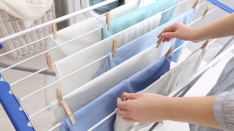 Person hanging laundry on rack