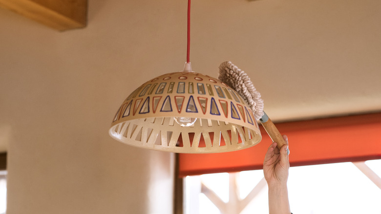 dusting a light fixture