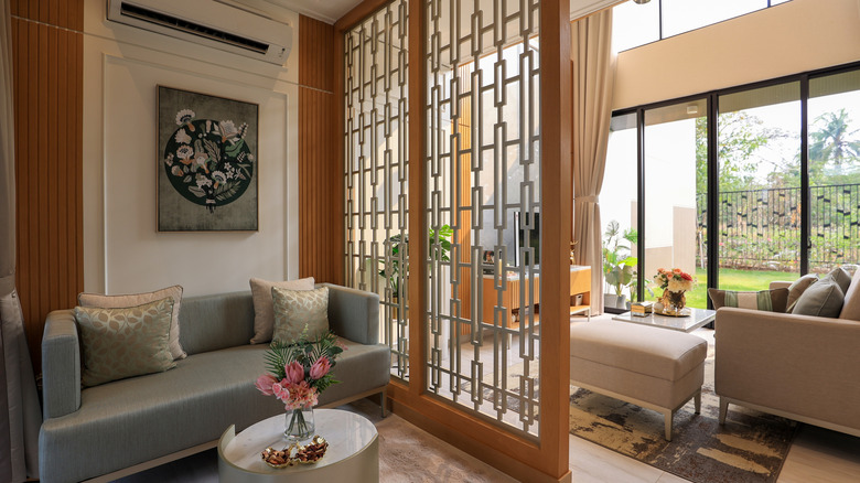 Open concept home with a unique room divider featureing wooden framing and an open metal pattern inside