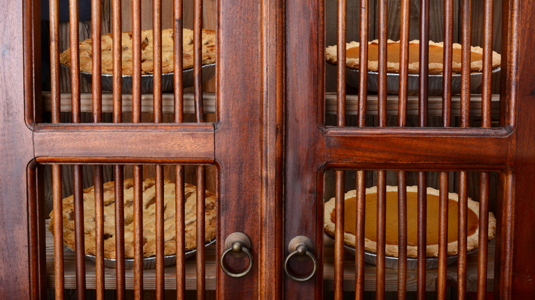 Antique pie safe with wood slats and brass hardware