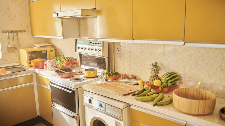 Vintage kitchen interior with yellow cabinets and classic appliances