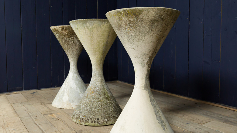 Three concrete Diablo hourglass-shaped garden planters